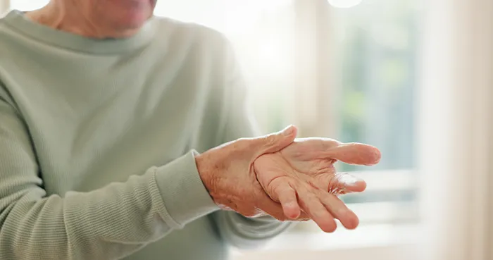 senior woman rubbing pain in hand